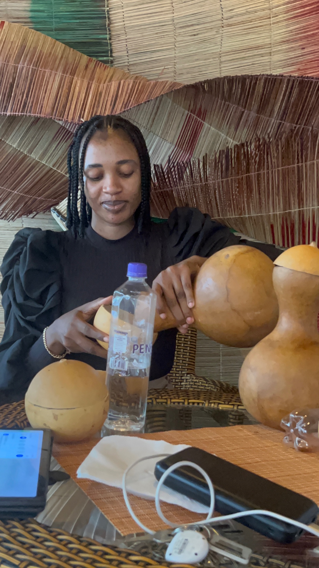 Palm wine being poured from traditional calabash gourds